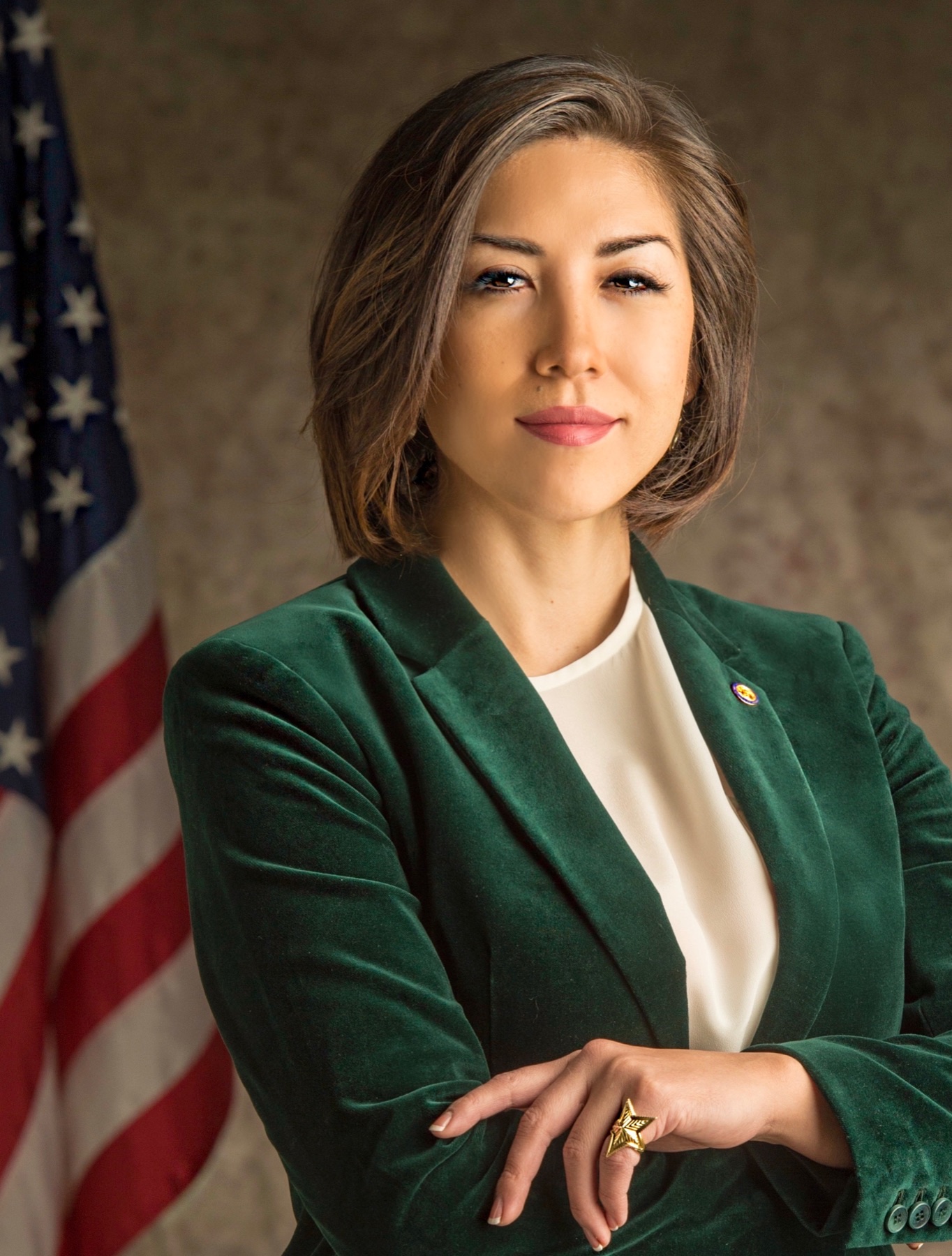 Portrait of Paulette in a deep green blazer, arms crossed